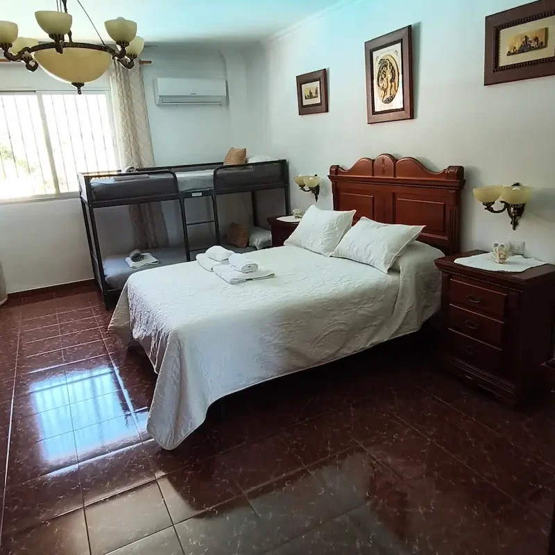Detalles cuidados para que tu celebración sea perfecta desde el primer momento. Habitación decorada con pétalos de rosa, globos y una cama con sábanas claras.