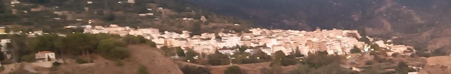 Vista panorámica de Lanjarón en un valle montañoso, rodeado de colinas.