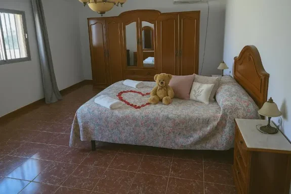 Habitación con cama, osito de peluche y decoración sencilla en tonos neutros.