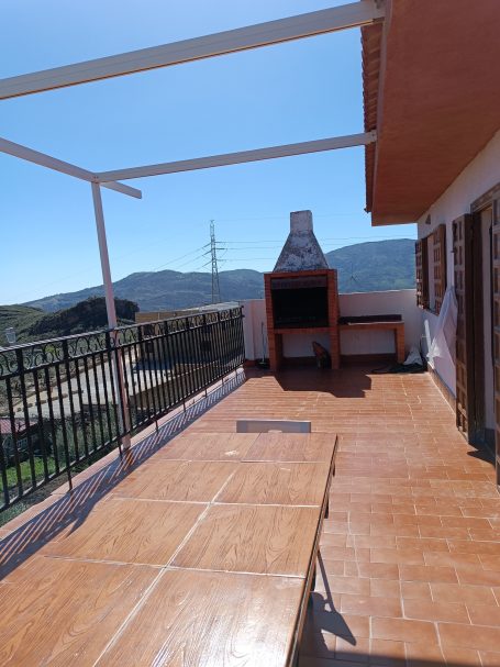 Terraza con barbacoa, vistas a montañas y cielo despejado. Suelo de azulejos.